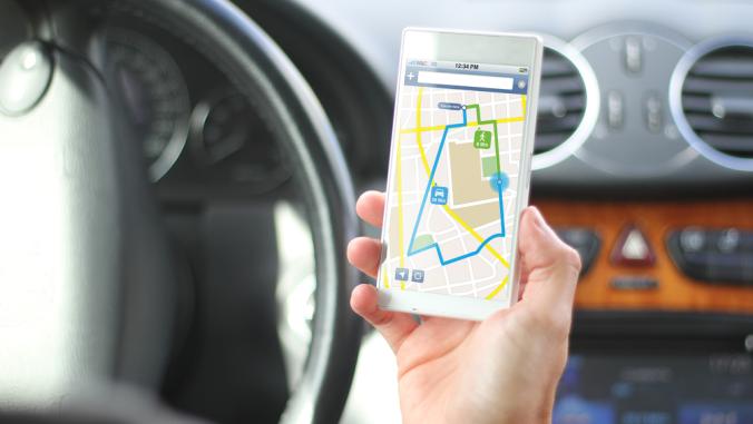 Driver holds phone that has mapped directions on screen