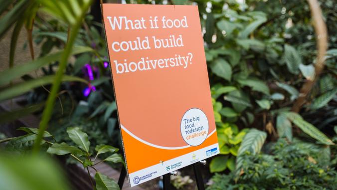 Orange sign that reads "What if food could build biodiversity" at Big Food Redesign Challenge launch event in 2023