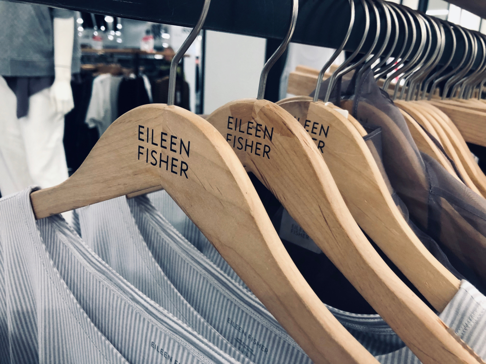 Rack of Eileen Fisher clothing for women on display at a Macy's department store in a mall