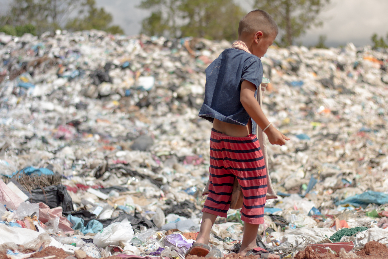 A child picks up recyclable waste in a landfill