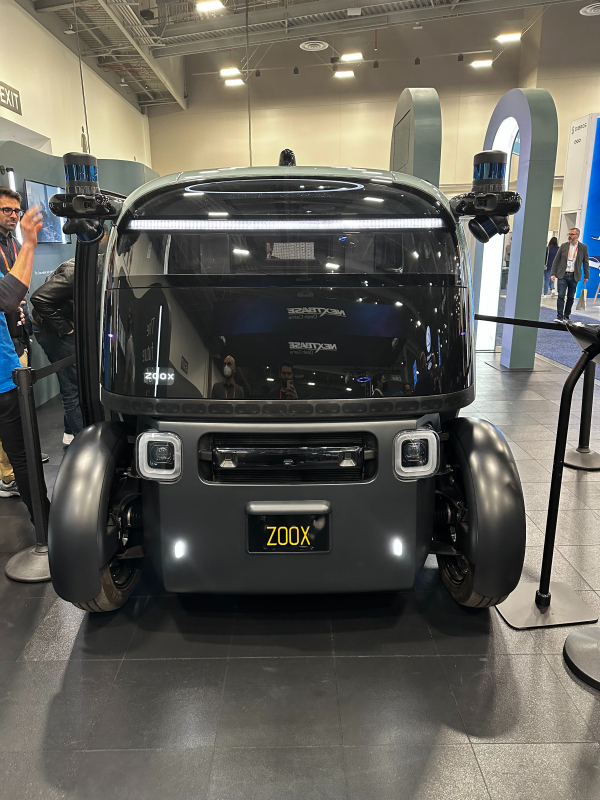 A front view of a dark gray Zoox vehicle on display at CES 2023.