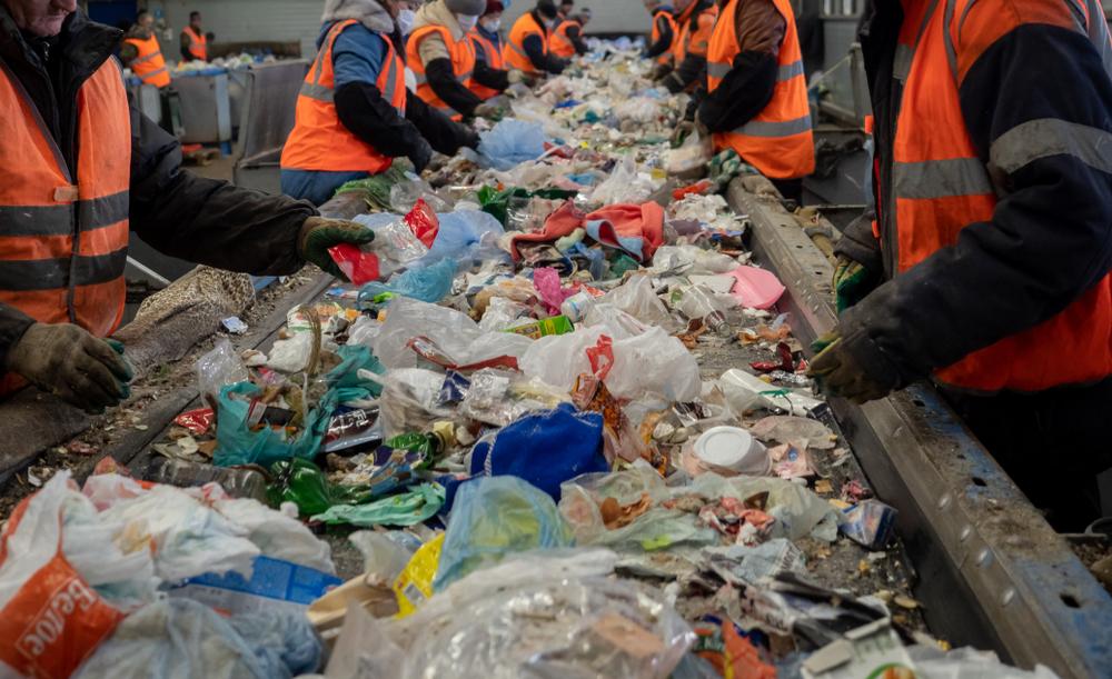 People sort waste in a recycling facility