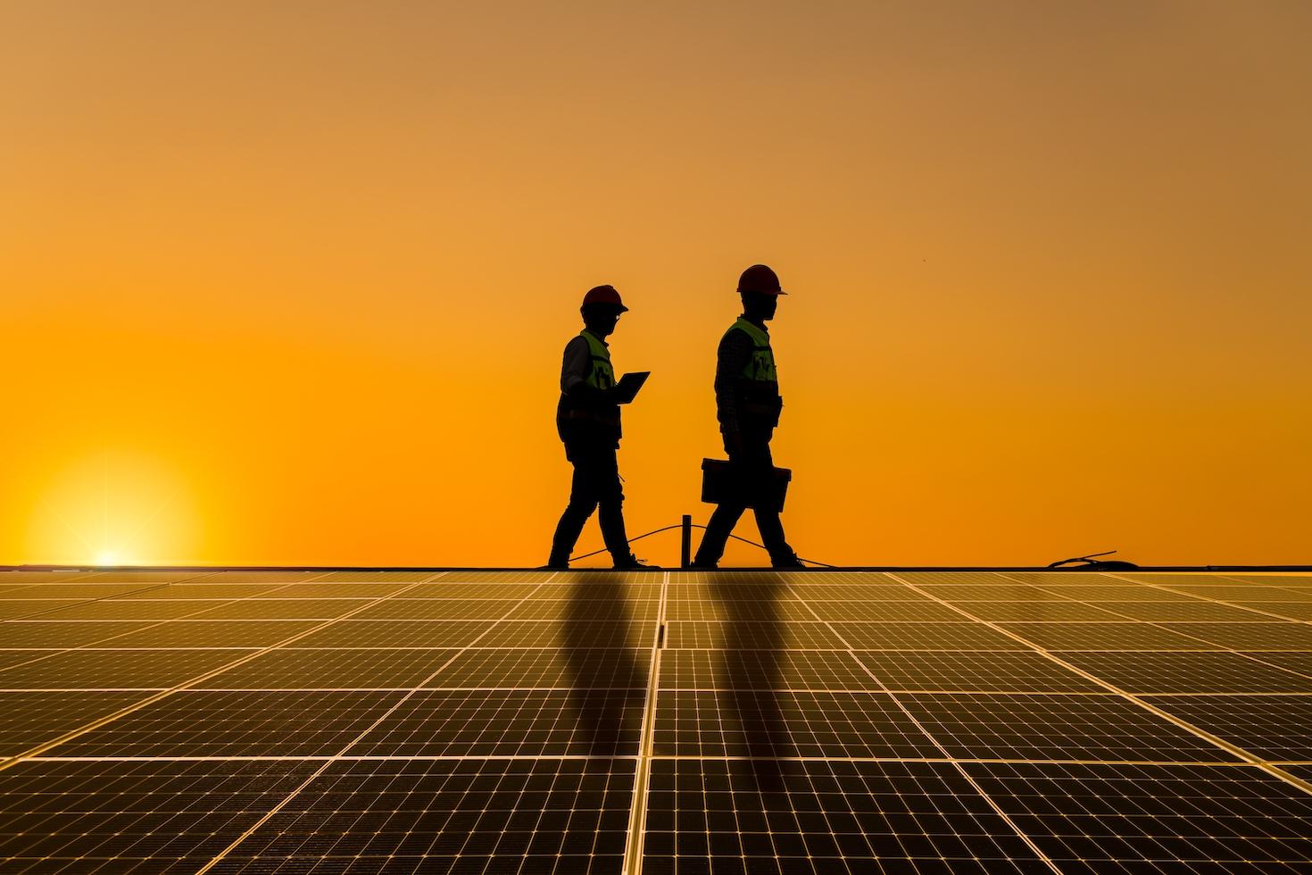 2 engineers walking on roof to inspect a solar panel