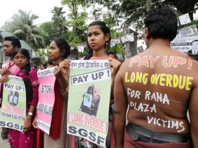 Demonstrators hold signs about Rana Plaza collapse 