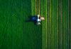 Aerial view of tractor working in a green field