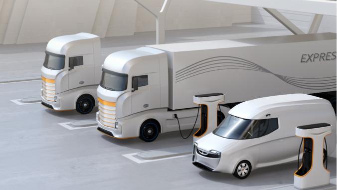 Illustration of heavy electric trucks charging at public charging station with roof-mounted solar panels.