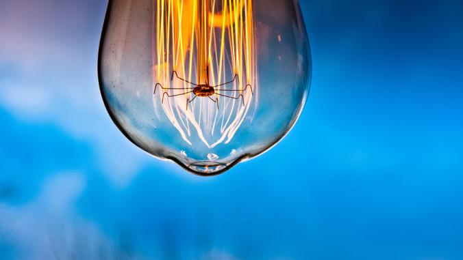 Incandescent light bulb with blue sky in background