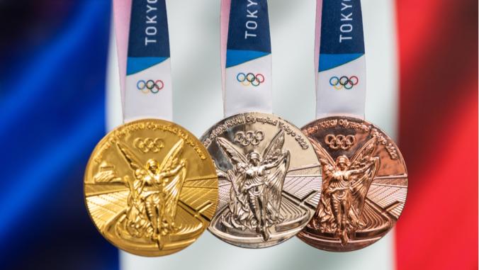 Gold, silver and bronze medals of the XXXII Summer Olympic Games 2020 in Tokyo on the background of the flag of France.