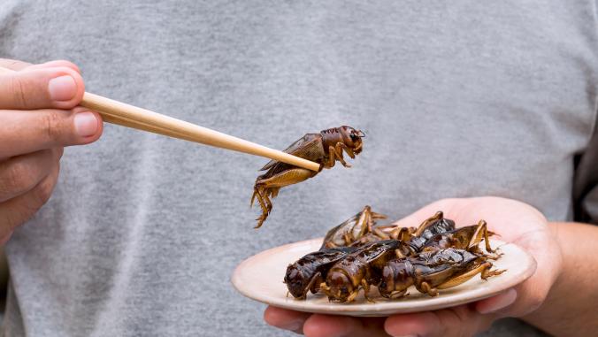 Man holding insect with chopsticks