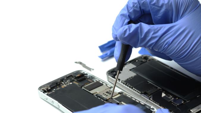 Technician repairing the smartphone's motherboard