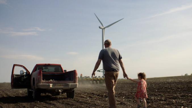 Man and daughter holding hands, walking across a farm field to a pick-up truck.
