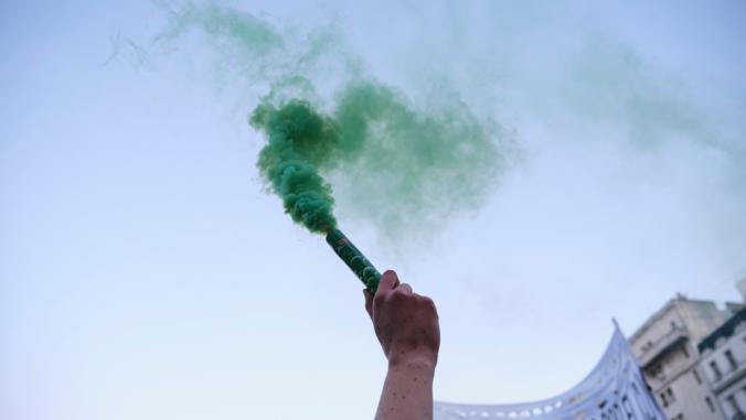 Arm raising a green smoke flare