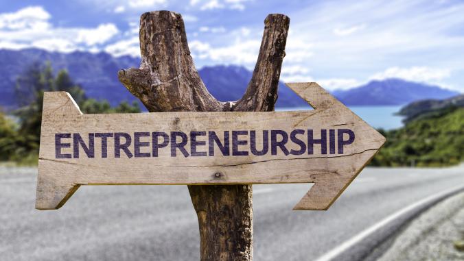 A picture of a wooden sign in the shape of an arrow with the word 'Entrepreneurship' hung on a stick