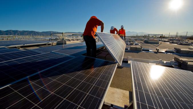 3 men installing solar panels on a Prologis building
