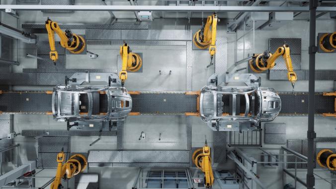 Aerial view of automated robot arm assembly line manufacturing of EVs